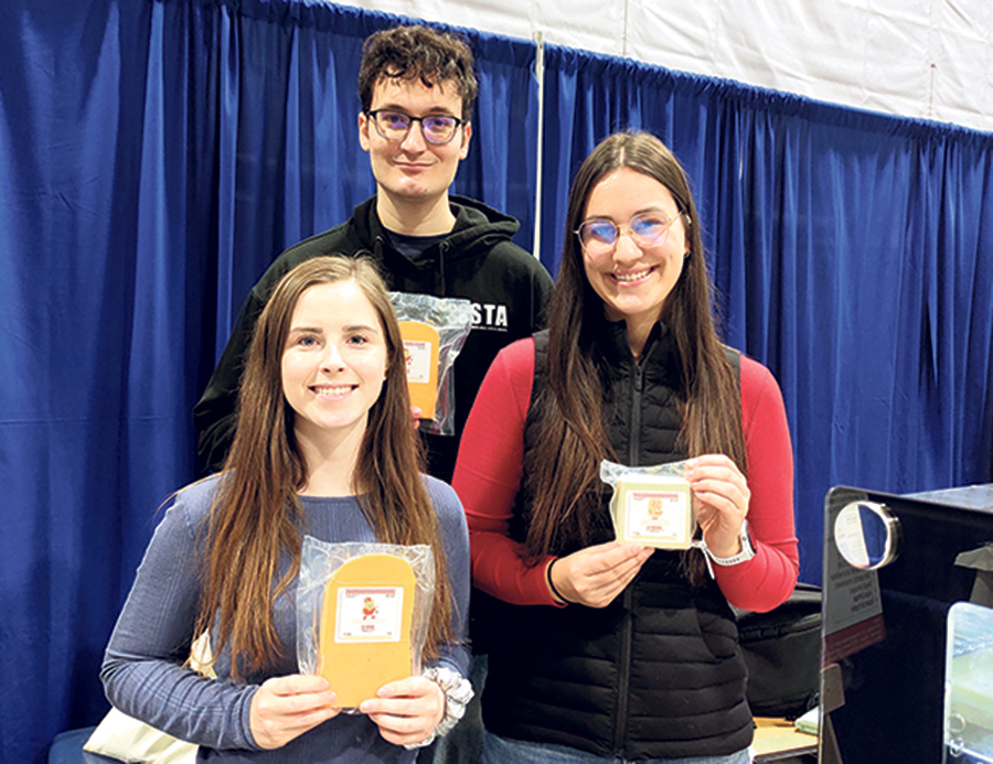 Allyson Guimont, Francis Villeneuve et Audrey Chouinard présentent fièrement certains des produits élaborés par la Fromagerie du Campus.