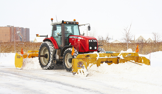 De nombreux producteurs agricoles utilisent des tracteurs de ferme pour déneiger des cours résidentielles ou commerciales. Plusieurs règles encadrent le déplacement de ces équipements sur la voie publique. © Martin Ménard