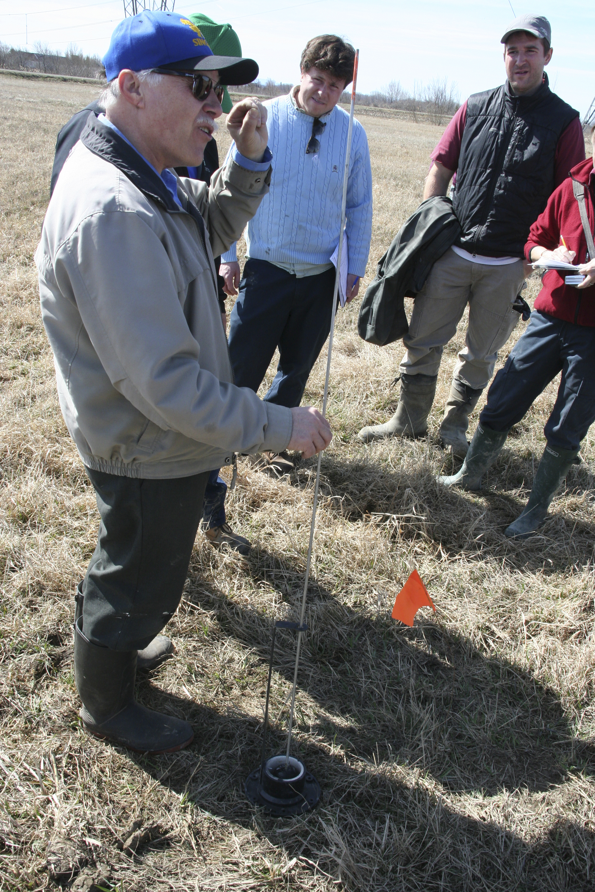 Robert Lagacé, ingénieur, agronome et professeur à l’Université Laval, explique le fonctionnement de la sonde à tige graduée pour évaluer la hauteur de la nappe d’eau.