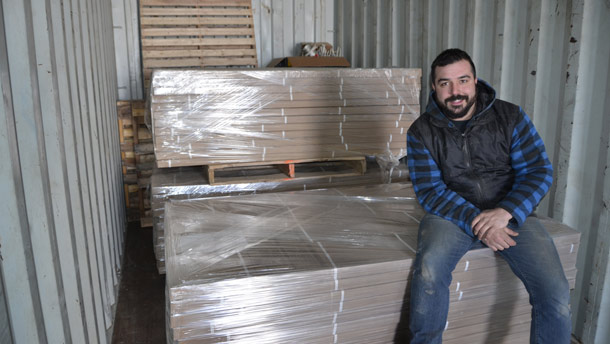 Le récupérateur Mikael Bourassa, installé sur l’un de ses chargements de bois recyclé destinés aux centres de rénovation. Crédit photos : Pierre Saint-Yves