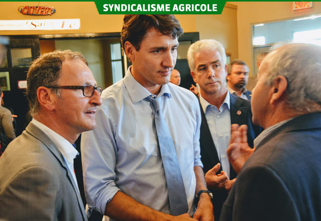 Justin Trudeau a rendu visite aux agriculteurs réunis en assemblée. Sur la photo, Gérard Bouchard lui fait part de ses inquiétudes au sujet de l’impact de l’entrée des fromages européens sur les petits producteurs canadiens. Crédit photo : Guillaume Roy