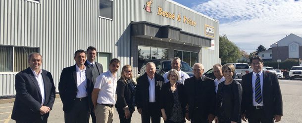 Sur cette photo, trois générations de Bossé dans l'entreprise, M. Lord Bamford au centre ainsi que des représentant de la compagnie JCB à Montmagny