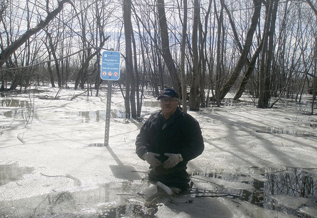 Georges Dutil debout sur ses terres à la limite des terres publiques de la baie Lavallière. Ce type de débordement se produit tous les printemps. Crédit photo : Georges Dutil