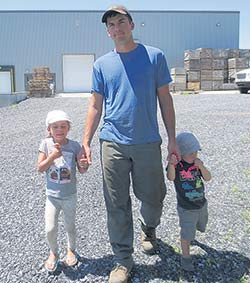 Gabriel, devant le nouvel entrepôt, en compagnie de ses enfants Mélodie et Julien. Crédit photo: Gracieuseté de la famille Samson