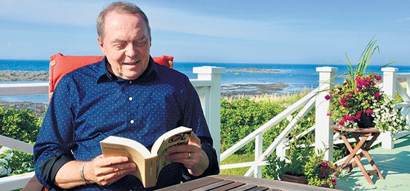 Sur sa terrasse orientée vers le fleuve, le journaliste et animateur Michel Désautels passe des heures à lire.
