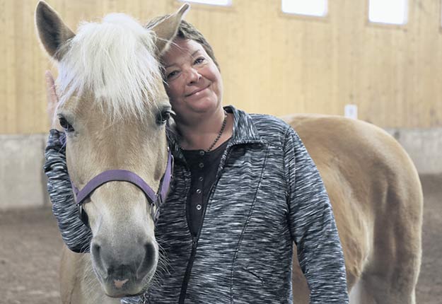 La directrice du Centre d’équithérapie La Remontée, Hélène Caron, avec une jument de 14&nbsp;ans prénommée Vie. Crédit photo : Maurice Gagnon