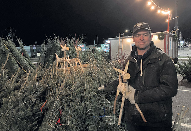 Le revendeur Stéphane Roberge dit que la demande pour les arbres de Noël est forte cette année. Il s’attend même à vendre les 1 500 chevreuils en bois qu’il a fabriqués avec sa conjointe. Photo : Martin Ménard/TCN