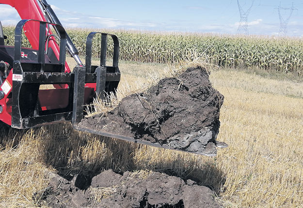 Évaluation d’un profil de sol avec une fourche et un tracteur. Photo : Gracieuseté de SCV Agrologie