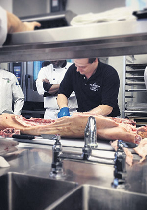 Alexandre Aubin préparant un porcelet de lait pour faire découvrir son produit à des restaurateurs. Photo : Gracieuseté de la Ferme Gaspor