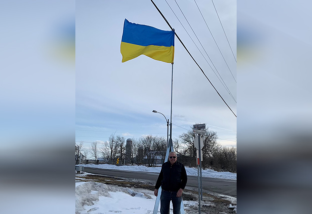 Normand Gagnon a hissé un drapeau ukrainien au-dessus de sa ferme pour inciter les producteurs à faire des dons à la Croix-Rouge. Photo : Caroline Charron