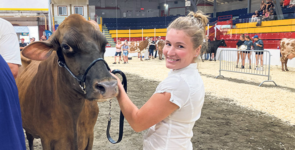 Marie-Ève Maher, fière de la position de Grande championne de sa vache. Photo : Martin Ménard/TCN