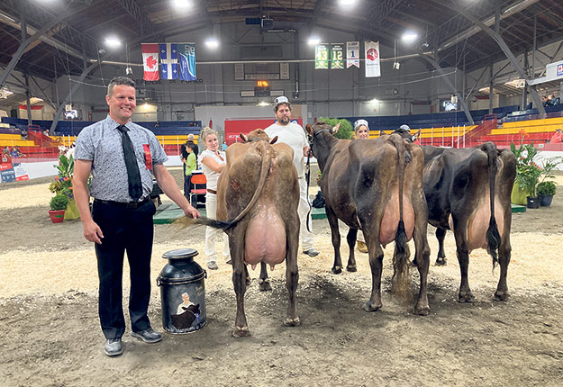 À gauche, les deux vaches gagnantes de la Ferme Britannia, accompagnées du juge Rémy Guay. Photo : Martin Ménard/TCN