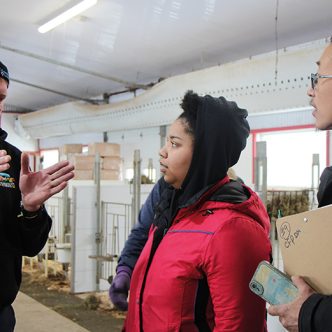 Mark Anderson (à gauche) explique à deux participants, Chanel Lavallée et Liu Zhi Chen, les principales tâches à faire pendant une journée typique à la ferme. Photo : Patricia Blackburn/TCN