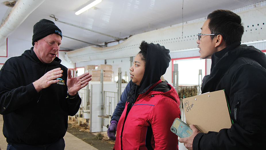 Mark Anderson (à gauche) explique à deux participants, Chanel Lavallée et Liu Zhi Chen, les principales tâches à faire pendant une journée typique à la ferme. Photo : Patricia Blackburn/TCN