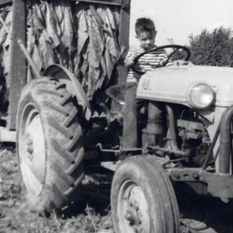 L'auteur a 8 ans, en 1956, et conduit le tracteur qui tire une voiture à tabac sur la terre de son oncle, à Saint-Césaire. Gracieuseté de François-Pierre Gingras