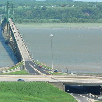 Des producteurs de l’île d’Orléans devront vivre jusqu’en 2028 avec les conséquences d’une limite de charge abaissée à 48 tonnes pour les semi-remorques sur le pont qui traverse le fleuve Saint-Laurent vers Québec. Photo : Gracieuseté de la MRC de L’Île d’Orléans