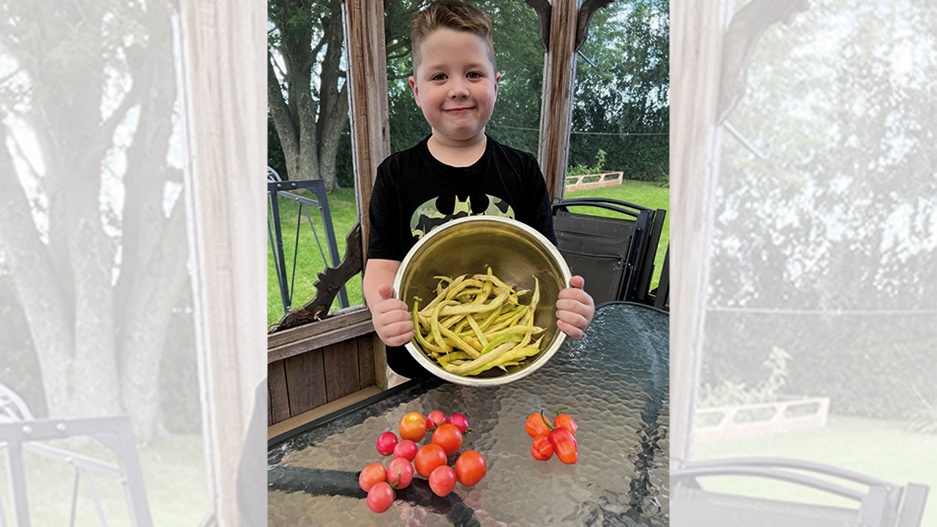 Logan Tétreault, 8 ans, est bien fier de sa récolte de légumes du jour. Photo : gracieuseté de Caroline Limoges
