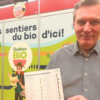 Alain Rioux, coordonnateur de QuébecBio, a accueilli les visiteurs de l’Expo Manger Santé et Vivre Vert pour leur remettre le dépliant du Parcours QuébecBio. Photo : Geneviève Quessy