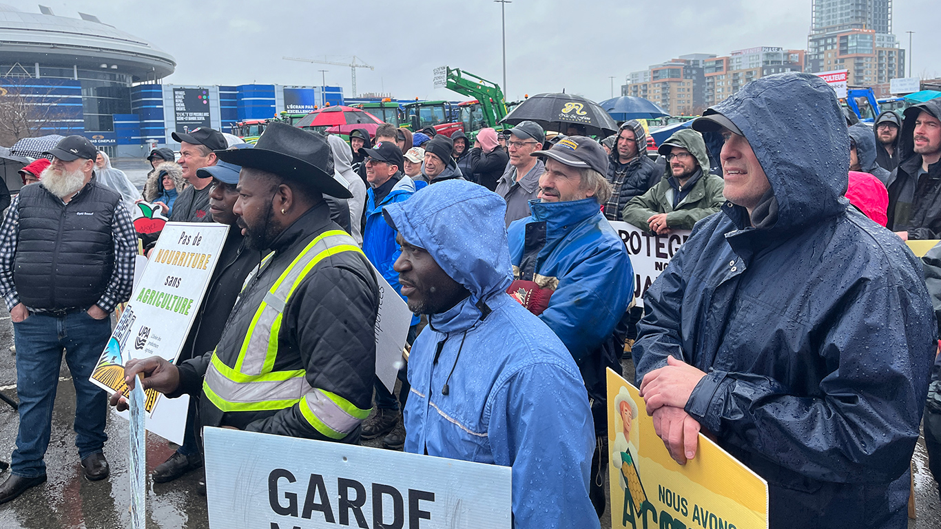 Environ 200 agriculteurs ont bravé la pluie pour se réunir à Laval, le 11 avril. Photos : Geneviève Quessy